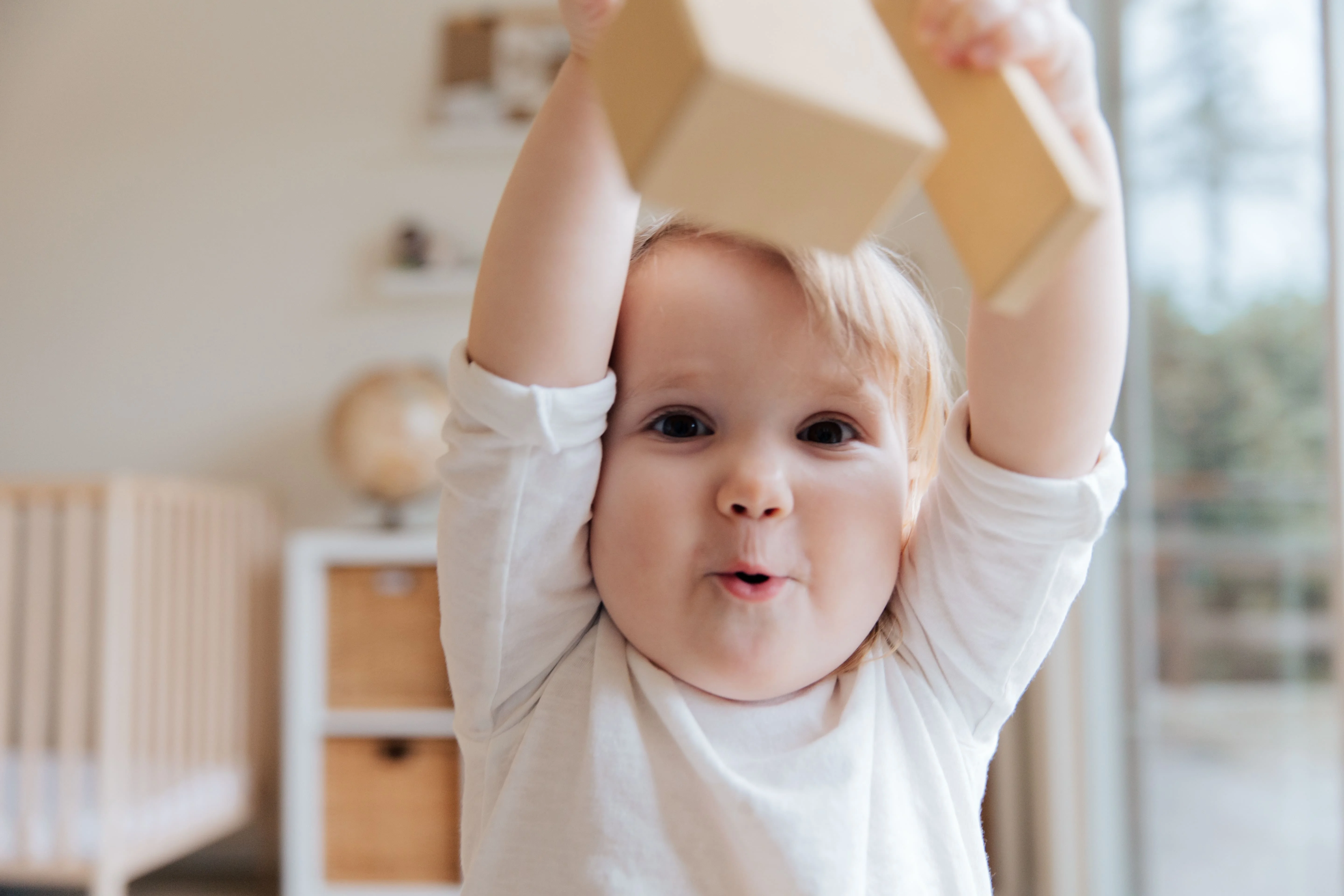 An infant is playing with blocks and showing physical changes in infancy.